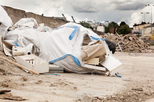 Front view of a skip and a parked delivery truck